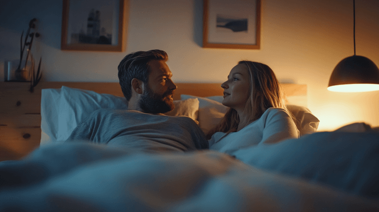 I den här bilden ser vi ett par som ligger i sängen i ett mysigt och avslappnat sovrum. Den varma belysningen från en lampa ger en intim och avslappnad atmosfär. Nyckelorden här är: par, sovrum, mysigt, belysning och avslappning.