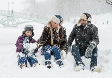 Happy family enjoying playful time in snowy winter park, capturing joyful moments in nature.