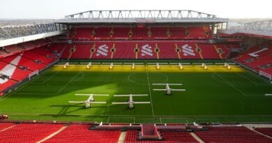 a soccer stadium with a green field and red seats