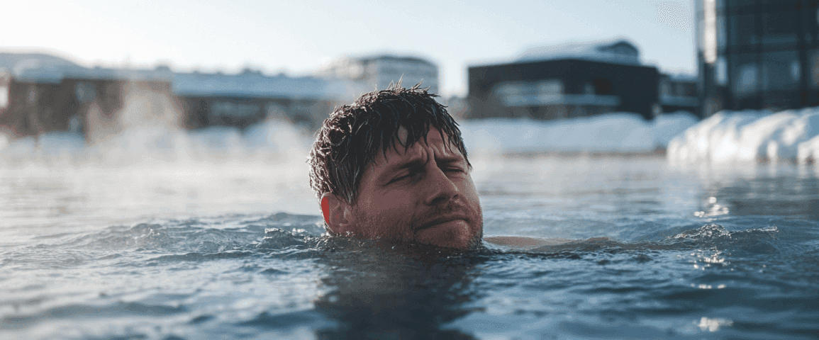 Midcent: En man njuter av ett uppfriskande vinterbad i en utomhuspool omgiven av snötäckta byggnader. Himmelen är klar och vattnet ångande varmt, vilket skapar en idyllisk vinterupplevelse. Kategori: Hälsa.