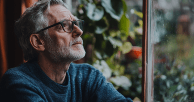 Midcent porträtterar en äldre man som eftertänksamt blickar ut genom ett fönster, omgiven av grönska. Den lugna atmosfären förmedlar stillhet och reflektion. Perfekt för kontextuellt innehåll inom personlig utveckling och mindfulness. Kategori: Samhälle.