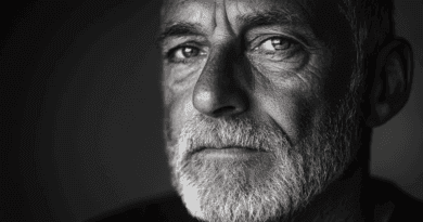 Svartvitt porträtt av en äldre man med intensiv blick och skägg, fångar djupa känslor och livserfarenhet. Midcent. Kategori: Samhälle.