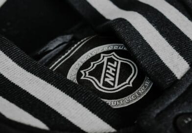 a black and white striped shirt with a badge on it