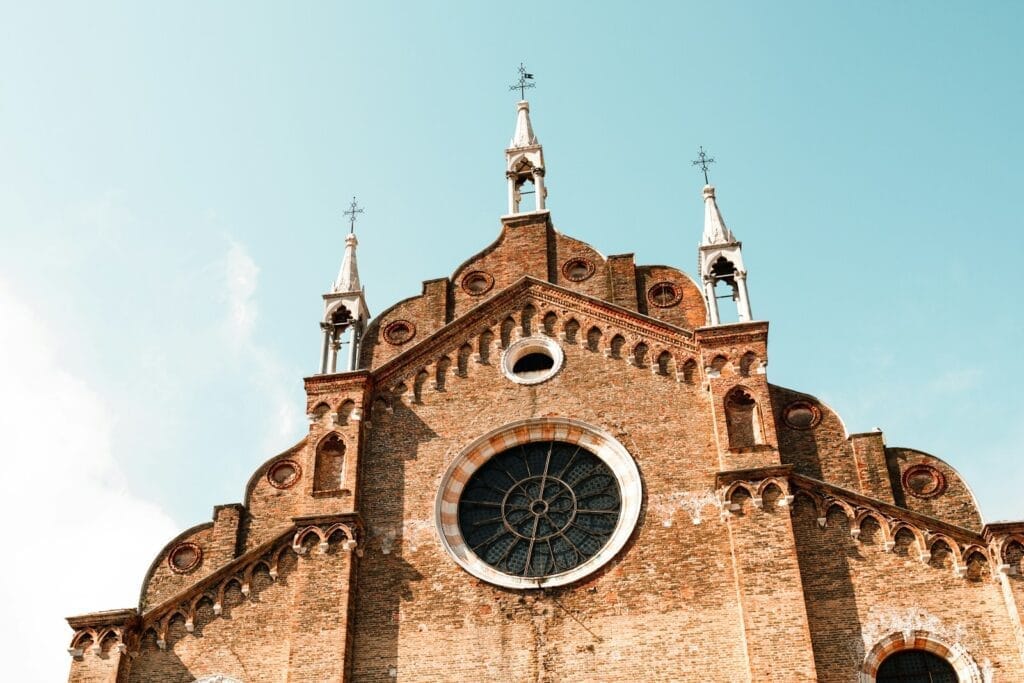 a tall brick building with a clock on it's side