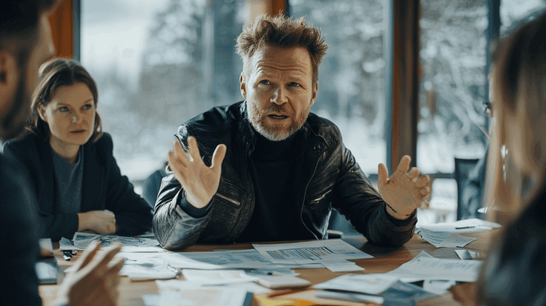 Midcent: I denna bild syns en engagerad man i en affärsmiljö, omgiven av dokument och kollegor, diskuterandes strategiska beslut. Perfekt för att illustrera affärsmöten och beslutsfattande.Kategori: Ekonomi.