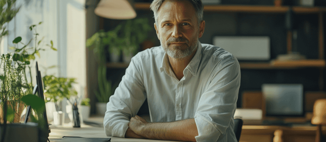 Midcent presenterar en stilren arbetsmiljö med fokus på naturliga element och komfort. En självsäker man i ljus skjorta sitter vid ett bord, omgiven av grönska och modern teknik. Inspirerande atmosfär för produktivitet och kreativitet. Kategori: Samhälle.