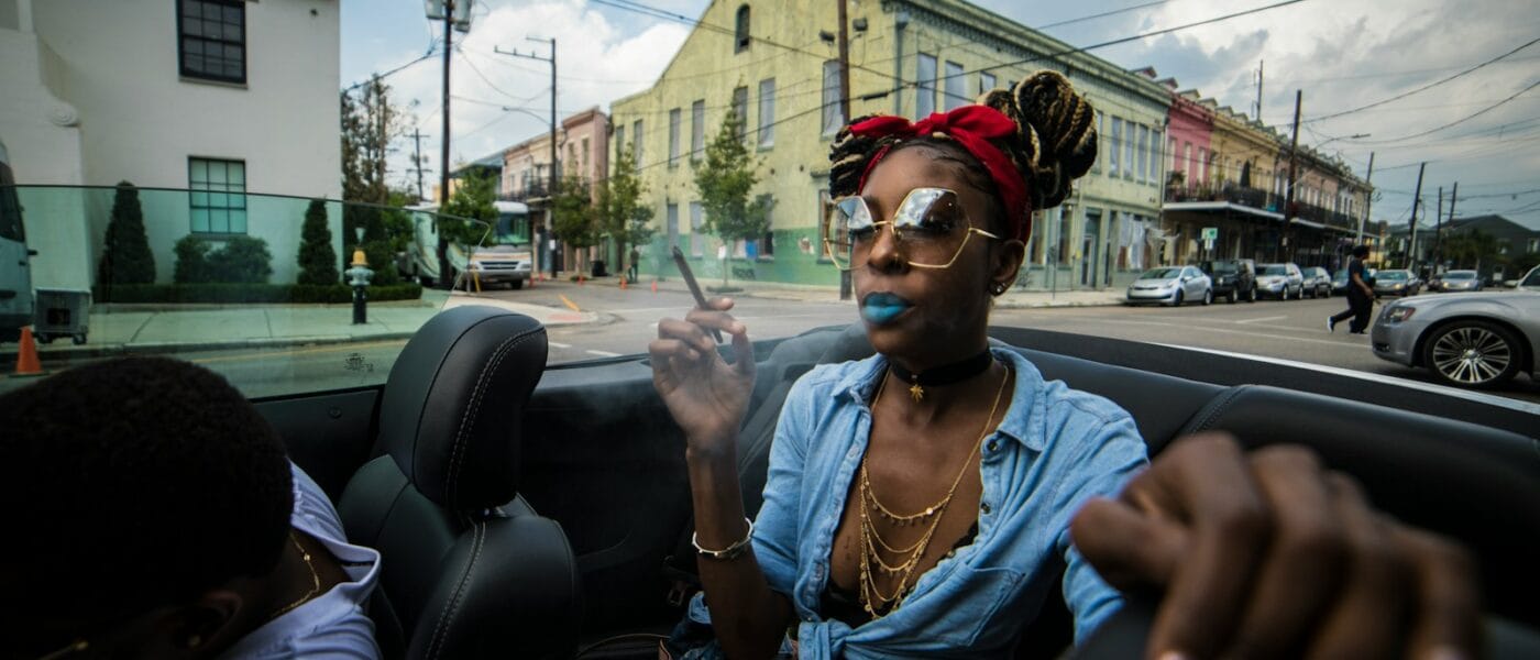 woman sitting on vehicle near concrete buildings