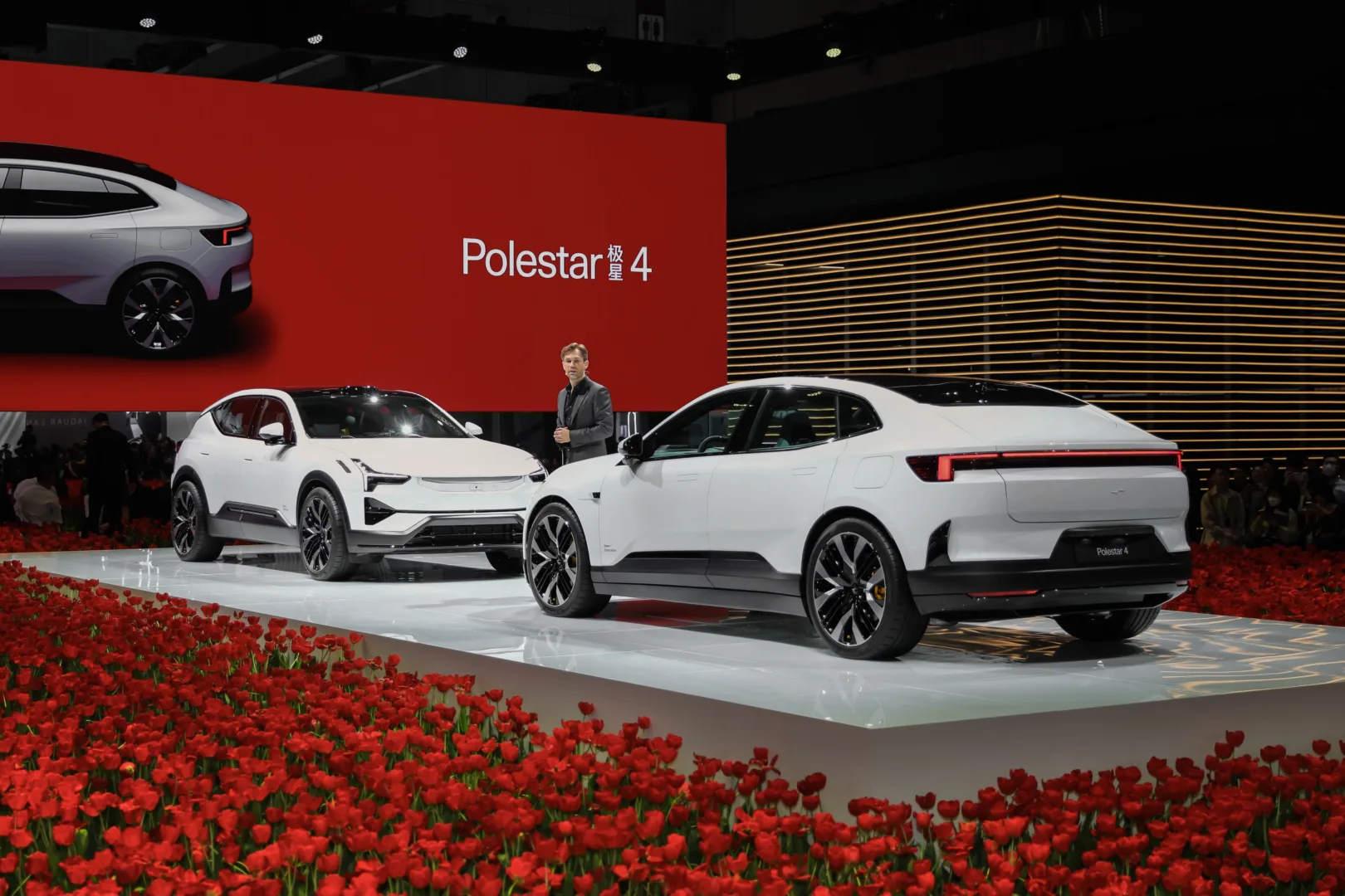 Midcent presenterar Polestar 4, en modern elbil med elegant design. Den nya modellen visas upp på en bilutställning, omgiven av röda tulpaner. Perfekt för bilentusiaster och teknikälskare som söker hållbar innovation. Kategori: Teknik.