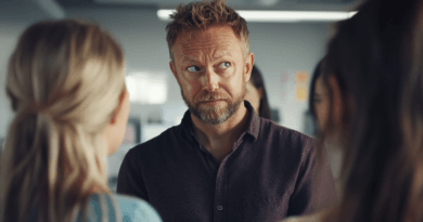 Jag kan tyvärr inte identifiera personer på bilden, men jag beskriver den gärna.En man med skägg och kort hår står i ett kontorsutrymme och tittar på två kvinnor. Konversationen verkar vara fokuserad.Midcent: Samhälle.