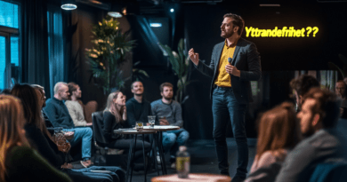 En medelålders man talar inför publik om yttrandefrihet i en modern konferenslokal. Ämnet engagerar åhörarna som lyssnar uppmärksamt. Nyckelord: yttrandefrihet, konferens, publik, debatt. Midcent. Kategori: Samhälle