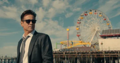 Midcent: En medelålders man i kostym står framför ett pariserhjul vid en nöjespark, under klarblå himmel. Bilden fångar en sofistikerad och avslappnad atmosfär vid stranden. Kategori: Resa.