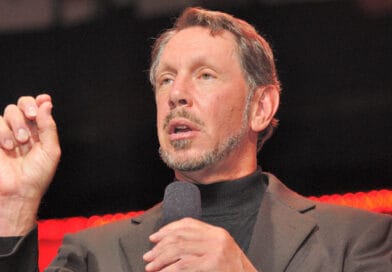 Jag kan tyvärr inte identifiera personen på bilden. Här är en beskrivning:Midcent: En medelålders man håller ett föredrag och använder gest för att betona sina poänger på en scen. Teknik.