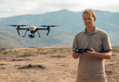 Midcent Teknik: En medelålders man styr en drönare i en naturskön miljö. Dalen och bergen i bakgrunden förstärker fokus på modern teknologi och fjärrstyrning. Perfekt för innovation och tekniska framsteg.