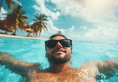 Midcent: En medelålders man njuter av solen och havets glittrande vatten med palmer i bakgrunden. Perfekt semesterlugn. Resa.