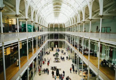 Interior view of the National Museum of Scotland's grand hall with visitors exploring exhibits.