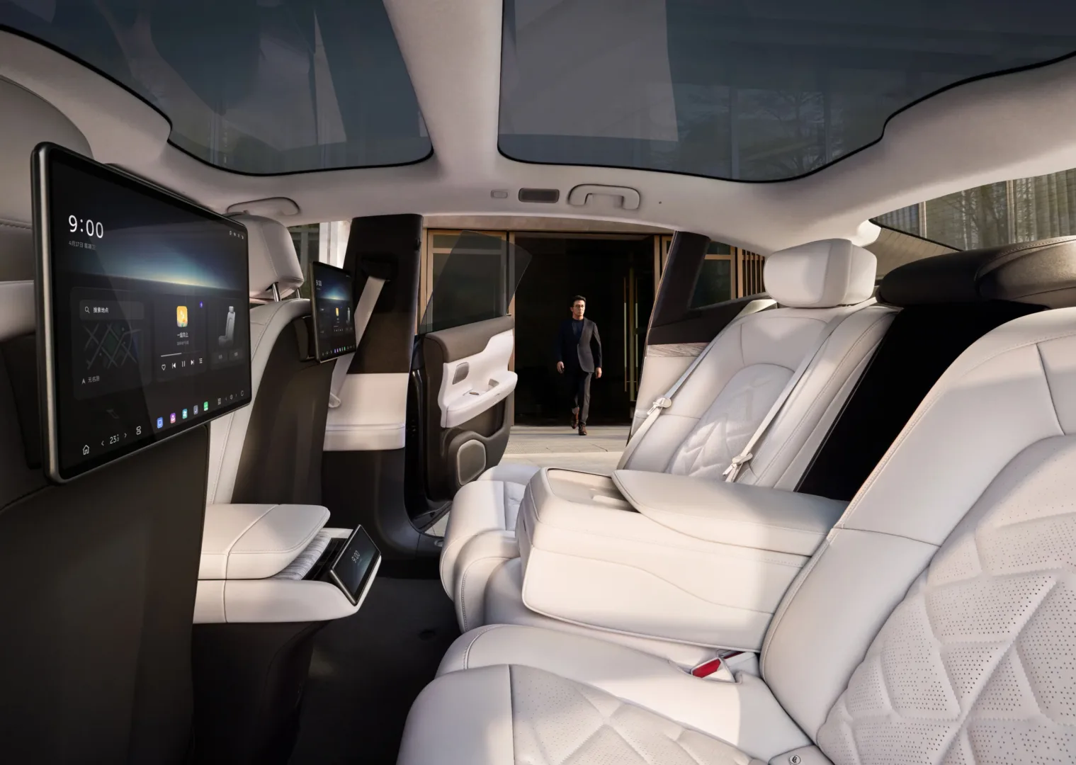 Midcent: Bilden visar interiören i en lyxig, modern bil med elegant design och avancerade skärmar, perfekt för dem som värdesätter komfort och teknik. En medelålders man syns i bakgrunden. Kategori: Teknik.