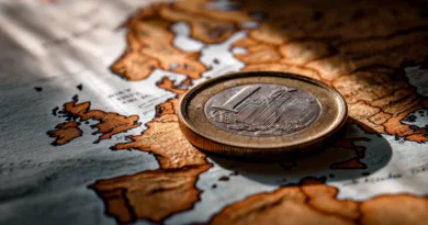 Midcent: Ett euro-mynt ligger på en karta över Europa, vilket symboliserar ekonomiska förbindelser och handel mellan länder. Fokus på finansiella rörelser och geografisk påverkan. Kategori: Ekonomi.