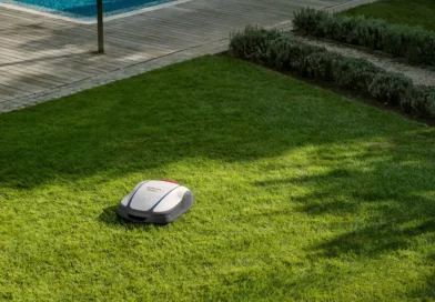 Midcent Teknik: En robotgräsklippare underhåller en grön gräsmatta vid en pool. Innovativ och effektiv lösning för trädgårdsskötsel, som sparar tid och energi för användaren. Perfekt för moderna hem och teknikentusiaster.
