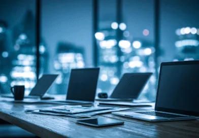 Midcent presenterar en modern arbetsmiljö med flera laptops uppställda i ett stilrent kontor, perfekt för produktivt samarbete och digital kreativitet. Kontorsskylinen skapar en dynamisk bakgrund. Kategorin är: Teknik.