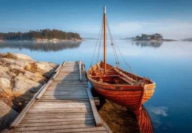 Midcent: En vacker, stilla sjö med en traditionell träbåt vid en brygga omgiven av skärgårdens klippor och öar. Perfekt för avkopplande naturupplevelser och friluftsliv. Kategori: Resa.