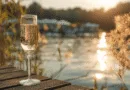 Midcent – Bilden visar ett glas champagne vid en sjö i solnedgång, vilket skapar en stämningsfull och avkopplande atmosfär. Perfekt för dem som söker njutning och lyx. Kategori: Resa.