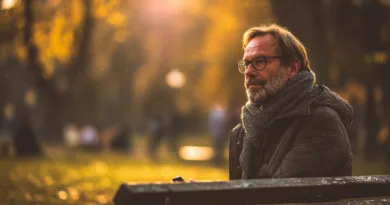 Midcent visar en medelålders man som reflekterar i en vacker höstpark. Mjuka solstrålar träffar omgivningen, vilket skapar en avslappnad atmosfär. Perfekt för att njuta av naturens skönhet.Kategori: Samhälle.