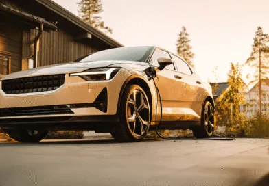 Midcent presenterar en modern elbil under laddning vid solnedgången, vilket symboliserar framtidens hållbara transportlösningar. Den gyllene belysningen ger en känsla av innovation och miljövänlighet.Kategori: Teknik.