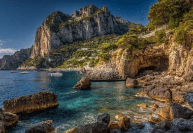 Midcent: Upptäck den natursköna skönheten på en klippig kust med kristallklart vatten och segelbåtar i Capri, Italien. En idyllisk destination för naturälskare och äventyrslystna resenärer. Perfekt för avkoppling och upptäcktsresor. Resa