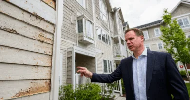 Midcent: En medelålders man inspekterar slitage på en husfasad. Bostäder.