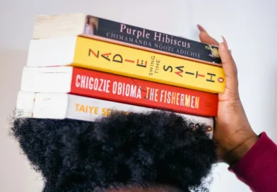 person carrying four assorted-title books on head