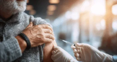 Midcent: En medelålders man får en vaccinering av en vårdgivare i en ljus, steril miljö. Fokus på hälsa och välbefinnande med skyddande klädsel och nål i förgrunden. Kategori: Hälsa.