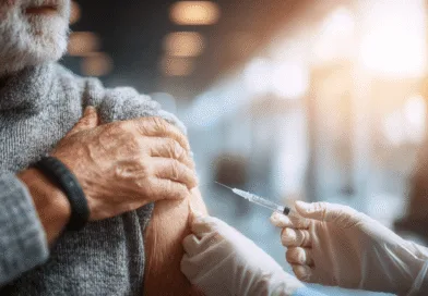 Midcent: En medelålders man får en vaccinering av en vårdgivare i en ljus, steril miljö. Fokus på hälsa och välbefinnande med skyddande klädsel och nål i förgrunden. Kategori: Hälsa.