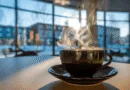 Midcent: En rykande kopp kaffe i ett mysigt kafé med stora fönster kring ett vintrigt landskap. Perfekt för en avslappnande paus eller inspirerande arbete. Kategorin: Mat.