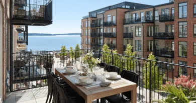 Lyxig balkongutsikt: Modern brickarkitektur med havsvy i förgrunden, elegant uppdukad middagsplats på solig altan. Perfekt för avkoppling och socialt umgänge. Midcent. Kategori: Resa.