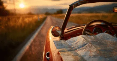 Solnedgång över landsväg sätter stämningen för en nostalgisk bilresa i en röd cabriolet, med karta i framsätet. Midcent. Resa.