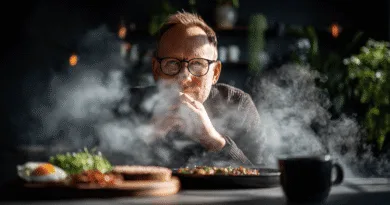 Midcent presenterar en atmosfärisk bild där en medelålders man reflekterar över ångande maträtter. Med fokus på kulinarisk njutning och gemenskap, fångas ögonblicket med skarp precision. Perfekt för alla matälskare och de som söker sinnesro.