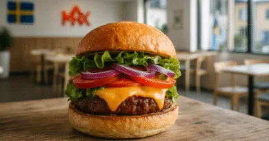 Midcent presenterar en saftig hamburgare fylld med ost, sallad, tomat och lök. Bakgrunden visar en svensk flagga och restaurangmiljö, vilket framhäver svensk matkultur. Perfekt för dig som älskar snabbmat och unika smakupplevelser. Kategori: Mat.