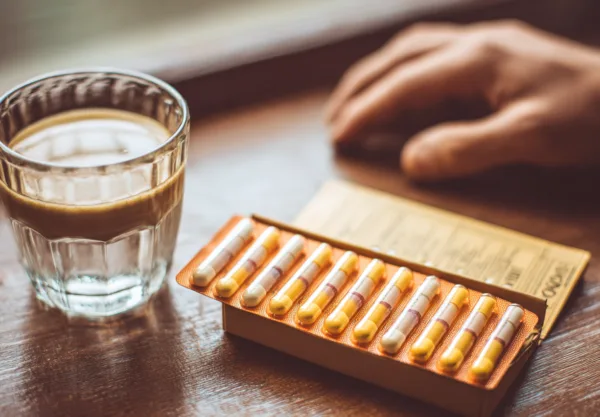 Midcent erbjuder en inblick i en medelålders mans vardag, med fokus på hälsoprodukter och drycker. I bilden syns en kopp kaffe och en förpackning med medicinska kapslar, som speglar dagens hälso- och livsstilsval. Kategori: Hälsa.
