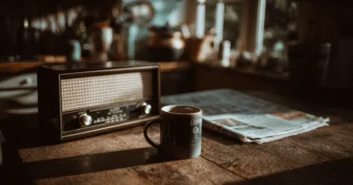 Radiovågornas sista suck? Därför dör inte FM trots podd-explosionen Midcent – En nostalgisk atmosfär med en klassisk radio, en kaffekopp och en tidning på ett träbord i morgonljus. Perfekt för att spegla stillheten i en traditionell start på dagen. Kategori: Underhållning.