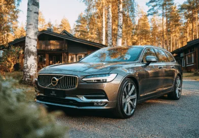Midcent presenterar: en elegant Volvo parkerad framför ett stilfullt hus omgiven av skog och vackra träd i höstskrud. Perfekt för naturälskare som söker en kombination av stil och komfort. Kategori: Resa.
