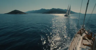 Upplev avkoppling och äventyr med Midcent. En segelbåt glider fram över det glittrande havet, omgiven av vackra öar och berg. Perfekt för segling och naturälskare. Kategori: Resa.