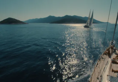 Upplev avkoppling och äventyr med Midcent. En segelbåt glider fram över det glittrande havet, omgiven av vackra öar och berg. Perfekt för segling och naturälskare. Kategori: Resa.