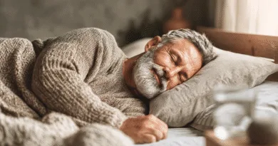 Midcent: En medelålders man njuter av en lugn och vilsam sömn i en mysig miljö. Bilden förmedlar känslan av komfort och avkoppling, perfekt för hälso- och välbefinnandeinnehåll. Kategori: Hälsa.