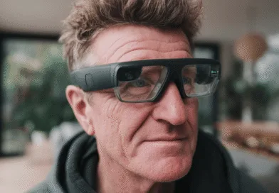 Midcent: En medelålders man med avancerade smartglasögon med futuristisk design. Skärpan i glasögonen indikerar interaktiva funktioner och tekniska innovationer. Perfekt för teknikentusiaster som söker nya upplevelser genom augmented reality. Kategori: Teknik.