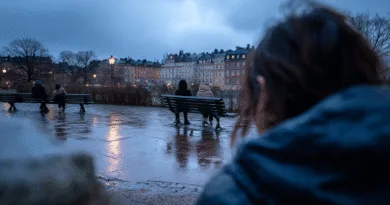 Midcent: En regnig kväll i staden, människor sitter på bänkar vid vattnet. Stämningsfull belysning reflekterar på den våta marken, omgiven av stadens arkitektur. Perfekt för en lugn promenad i skymningen. Kategori: Resa.