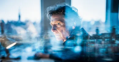 Midcent: En medelålders man arbetar fokuserat vid en dator med teknik och analys i ett modernt kontorslandskap. Bilden förmedlar teknisk innovation och framtidsinriktade lösningar. Kategori: Teknik.