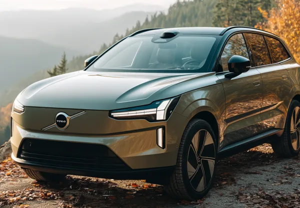 Volvo SUV parkerad i en naturskön miljö, omgiven av höstlöv och bergslandskap. Den moderna designen och panoramavyen
