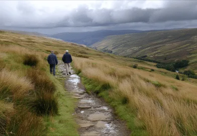 Midcent: En medelålders man och en vän vandrar genom ett naturskönt landskap med gröna kullar och dramatiska molnformationer i bakgrunden. Idealiskt för naturälskare och friluftsliv. Kategori: Resa.